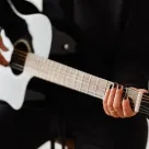 Persona tocando una guitarra acústica