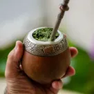 Mano sosteniendo un mate con yerba