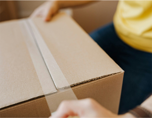 Imagen de un trabajador embalando una caja