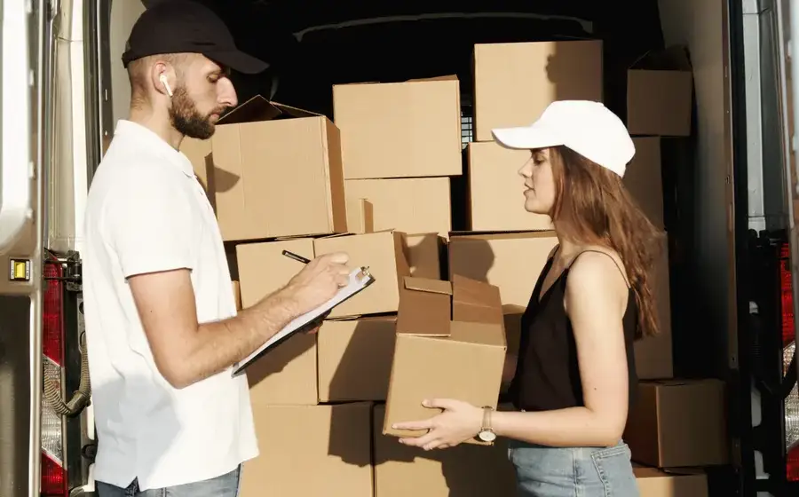 Repartidor entregándole cajas a una clienta